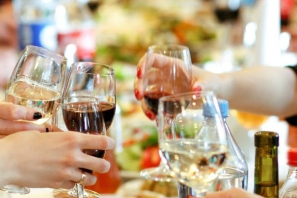 a person sitting at a table with wine glasses